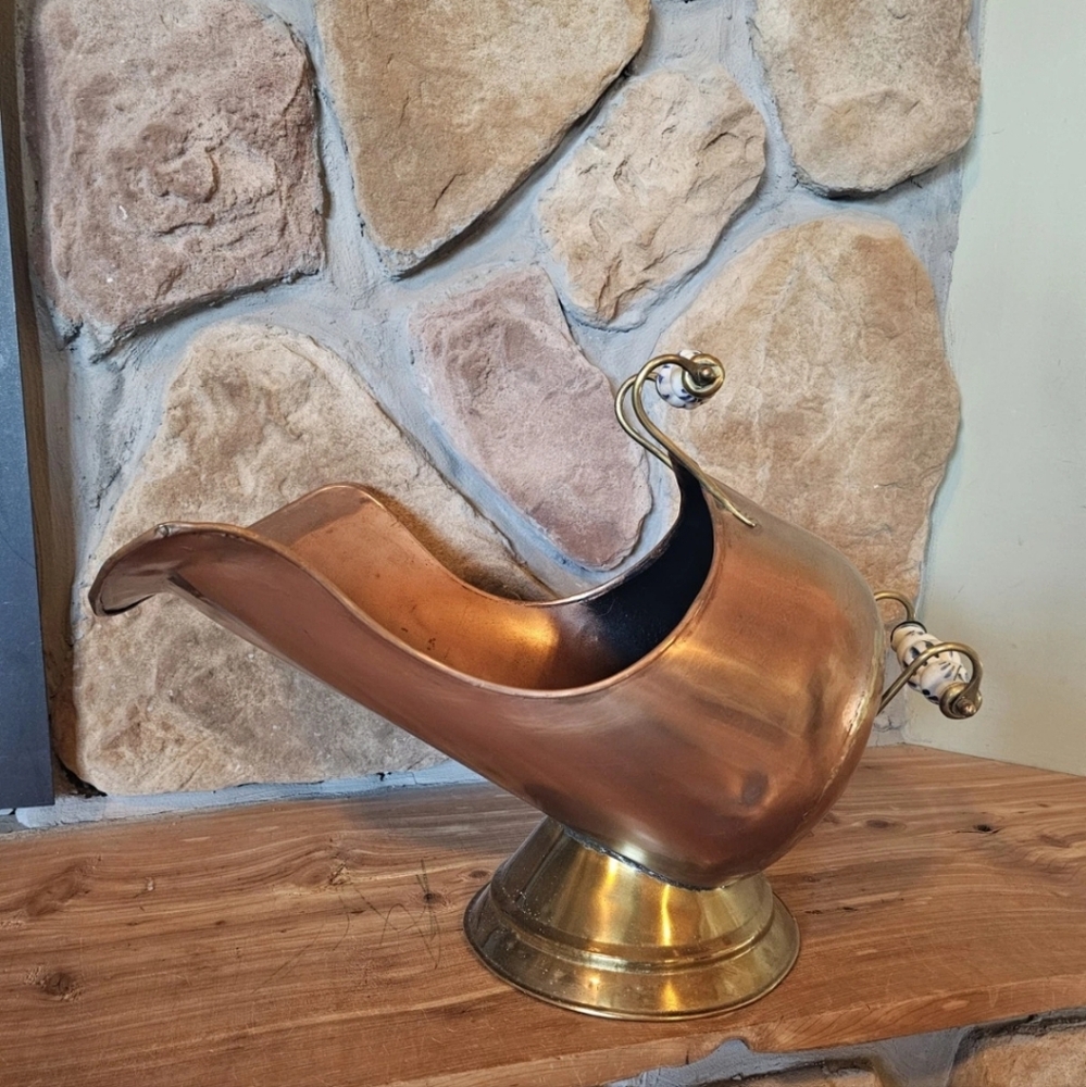 Vintage copper and brass coal scuttle, used for holding coal next to a fireplace
